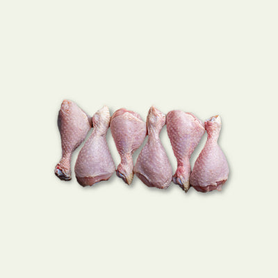 Five raw chicken legs on a light gray background